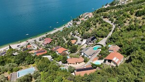 Vista aérea de una zona residencial costera con casas, una piscina y una playa.