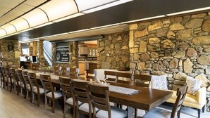 Un restaurant dont l’intérieur est décoré de murs en pierre, avec des tables et des chaises en bois, et sur lequel on peut lire une enseigne indiquant « Leon Russell Enterprises » et « Paradise Records ».