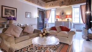 A living room with two sofas, a coffee table, and a vase of flowers. - Palazzo Costaguti – La Dimora del Tempo (Roma)