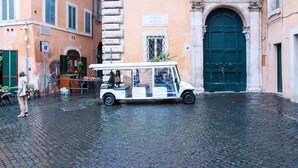 A vintage car parked in front of a building with a sign reading "COSTAGVTI" and "Piazza Mattei". - Palazzo Costaguti – La Dimora del Tempo (Roma)