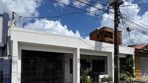 A residential building with two garage doors, a concrete driveway, and a utility pole with overhead wires.