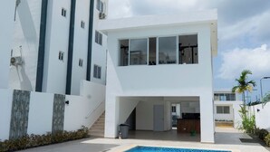 Un bâtiment moderne à deux étages avec une piscine à l’avant.