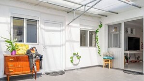 Una habitació lluminosa amb un armari de fusta, una taula petita i un televisor.