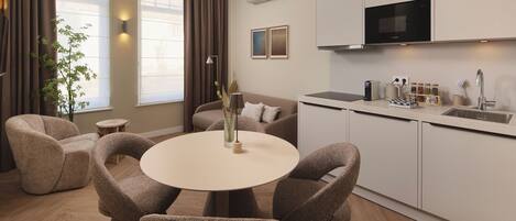 A modern kitchen with white cabinets, a built-in microwave, and a sink.