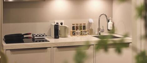 A modern kitchen with a built-in stove, a coffee maker, and a sink.