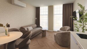 A modern living room with a sofa, chairs, a small table, and a TV. - Zenstay Hotel Amsterdam - Zaandam (Zaandam)