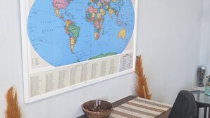 A room with a wooden desk, a black office chair, a world map, and an air conditioning unit. - Sweet Dreams by the Pool - V (Smiths)
