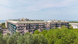 A multi-story hotel with balconies, a flat roof, and a view of the sea. - Fabulous Apartment With Premium Amenities (San Michele al Tagliamento)