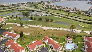 Un campo da golf con piscina, circondato da edifici residenziali con tetti rossi.