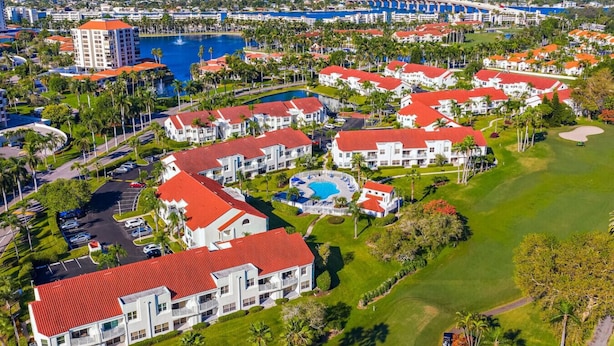Un resort con diversi edifici, una piscina centrale e un campo da golf.