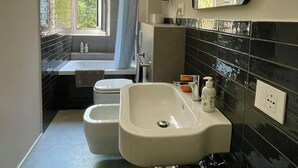 A modern bathroom with a bathtub, toilet, and sink.