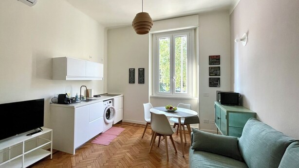 A compact living space with a kitchenette, a dining area, and a seating area.
