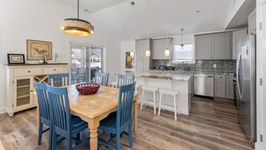 A modern kitchen with a central island, white cabinetry, and stainless steel appliances. - Modern Beach Condo: Walk to Beach & Boardwalk (Wildwood)