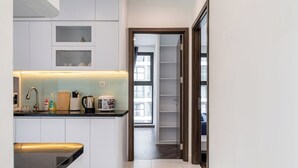 Una cocina moderna con armarios blancos, encimera negra y horno empotrado. Se aprecia una ventana con vistas al exterior.