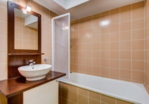Un baño con lavamanos, espejo y bañera.