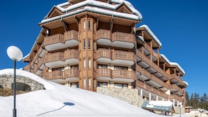 Ein mehrstöckiges Holzgebäude mit Balkonen, umgeben von Schnee.