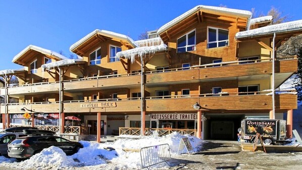 A multi-story wooden building with balconies, a sign for 'Central Park', and a 'Rotisserie Trattier' sign.