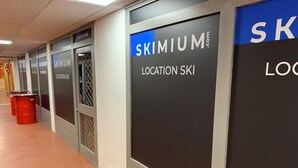 Un pasillo con puertas que indican 'SKIMIUM LOCATION SKI'.