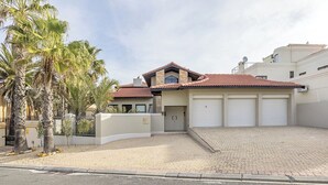 Ett tvåvåningshus med ett rött tegeltak, ett garage med tre portar och en asfalterad uppfart.