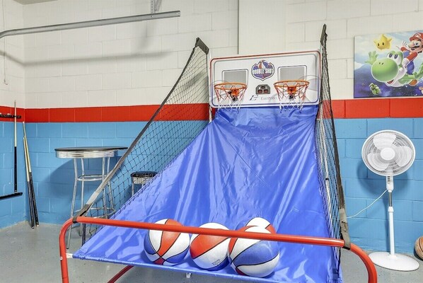 A basketball court with a blue mat, two basketball hoops, and a fan. - Windsor Swanky (Kissimmee)