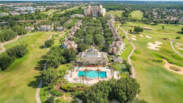 A golf resort with a central pool, multiple buildings, and surrounding greenery. - Reunion Swanky (Kissimmee)