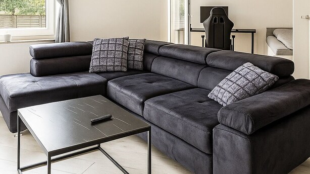 A modern living room with a sectional sofa, a coffee table, and a side table. - Charming apartment with terrace and parking space near the Rhine and Bonn city center (Bonn)