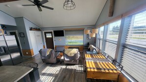 Un espacio habitable compacto con kitchenette, un sofá, una mesa de comedor y un ventilador de techo.