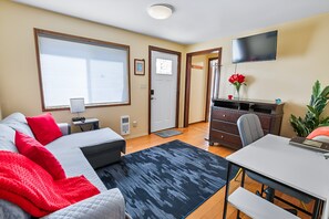 Een moderne slaapkamer met een bed, nachtkastje en bureau met stoel.