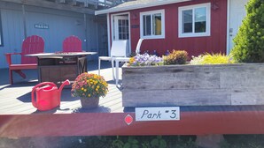 Un patio con una mesa y sillas, un balde rojo y un letrero que indica 'Parque #3'.