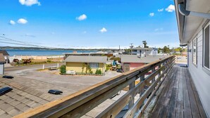 A balcony with a view of a beach and a parking area. - Studio with covered deck and Birch Bay View (Blaine)