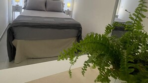 A bedroom with a bed, two bedside lamps, a window, and a potted plant. - Historic Holiday Home Il Melograno where tranquility reigns supreme (cavallino)