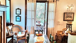 Comedor con una mesa larga, sillas y vistas al exterior.