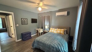 A bedroom with a bed, a desk, a chair, a ceiling fan, and an air conditioning unit. - Welcoming 3-bedroom house near charming Mount Ida and Lake Ouachita! (Mount Ida)