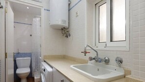 Un baño con inodoro, lavadora y lavabo.