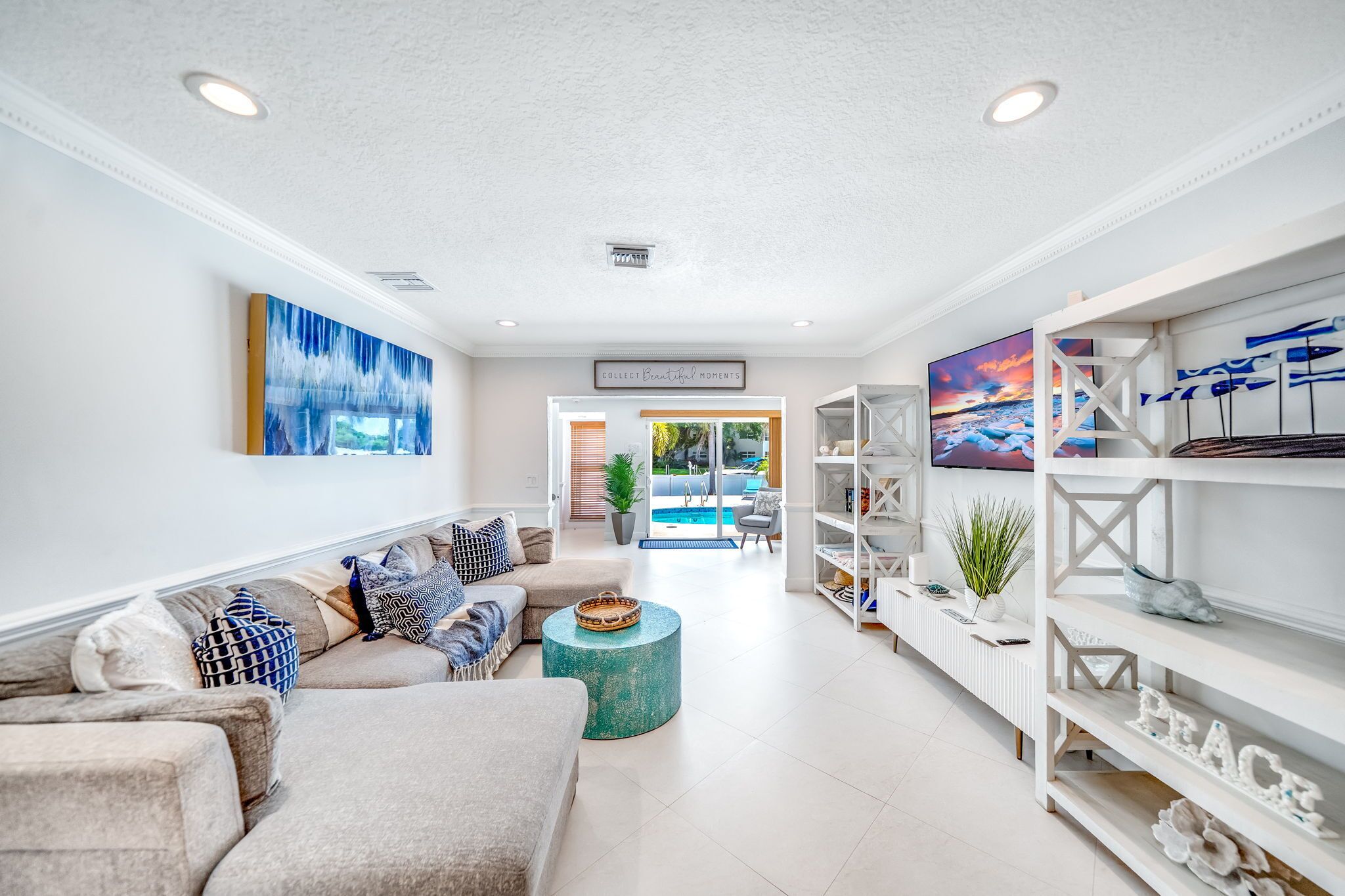 A spacious living room with a sofa set, a coffee table, and a bookshelf.