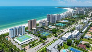 Zona residencial costera con edificios altos, una playa y un complejo deportivo.
