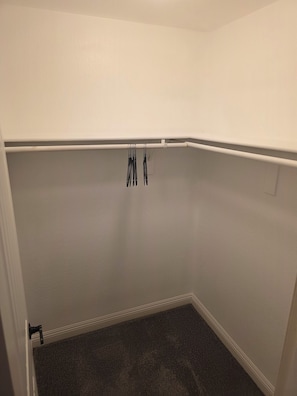 A small, empty room with white walls, a dark carpet, and a white ceiling. - Pet-Friendly 4 bed Home w/ Pool Access, Patio & Garage – Walk to Dining! (Gilbert)
