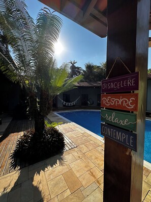 Uma área de piscina com uma placa que diz 'DESACELERE RÉSPIRE relaxe contemple'.