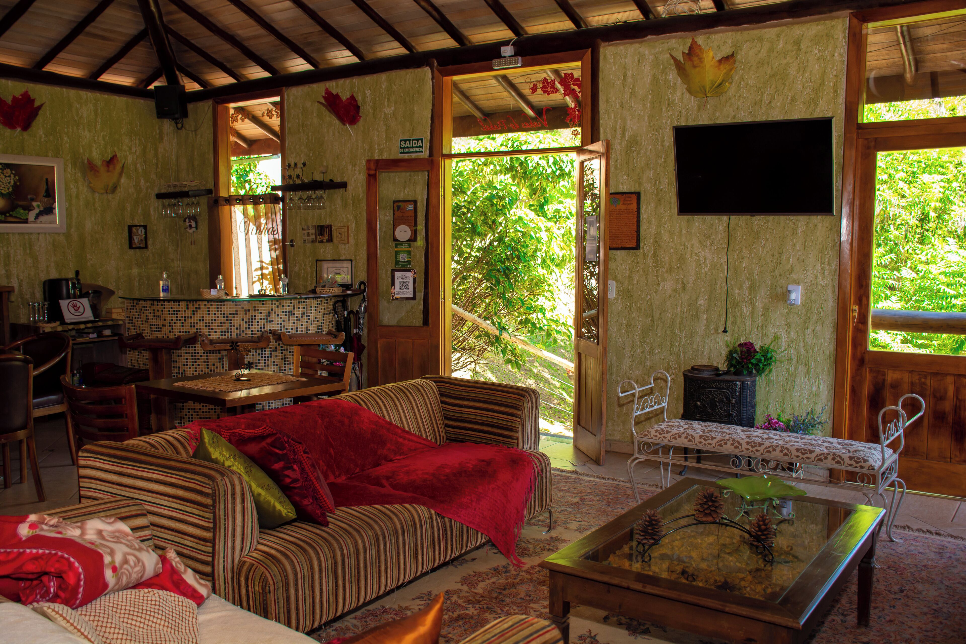 A cozy room with a striped sofa, a coffee table, and a dining area with a wooden table and chairs.