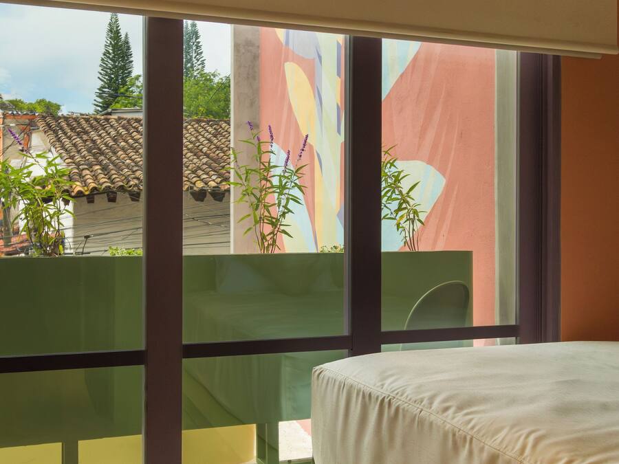 Un dormitorio con un ventanal grande, una cama y vistas al exterior.