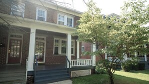 A two-story brick house with a front porch, a small tree, and a well-maintained lawn. - Hamilton Hideaway (Hagerstown, MD) (Hagerstown)