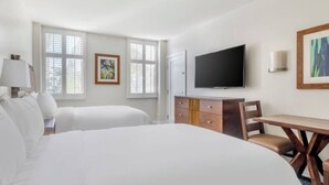 Una habitación de hotel con dos camas, televisión, escritorio y cómoda.