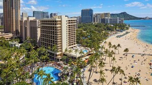 Un hotel con piscina, playa y el horizonte de la ciudad.