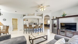Un vaste espace de vie comprenant une cuisine moderne, un coin repas et un salon avec des canapés et une table basse.