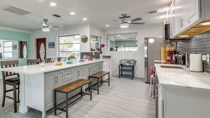 Una cocina moderna con una isla central, electrodomésticos integrados y amplio espacio en las encimeras.