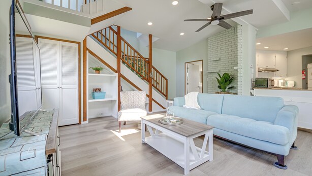 A spacious living area with a light blue sofa, a wooden coffee table, a white armchair, and a staircase with wooden railings. - < 1 Mi to Lake Washington: Peaceful Apt in Kenmore (Kenmore)