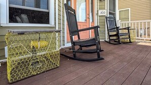 A porch with two rocking chairs and a yellow fishing net.