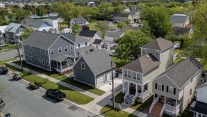 A residential area with houses, a street, and a body of water in the background.