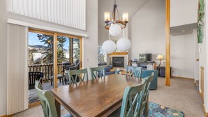 A dining area with a wooden table and chairs, a chandelier, and a fireplace. - Mountain Retreat Near Skiing & Golf w/ Views (Silverthorne)
