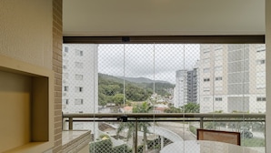 Ein Balkon mit Blick auf eine Stadtlandschaft und Berge.